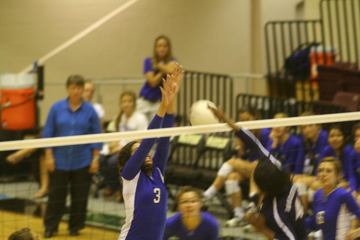 Blake Johnson (10) deflects the oncoming spike.