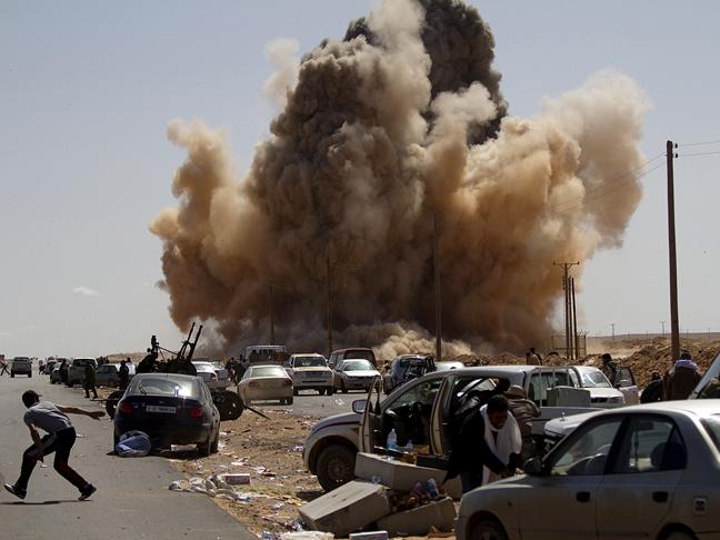 Libyan rebels fleeing from an Air Force Jet Fighters bomb outside of an oil port. photo by Getty Images