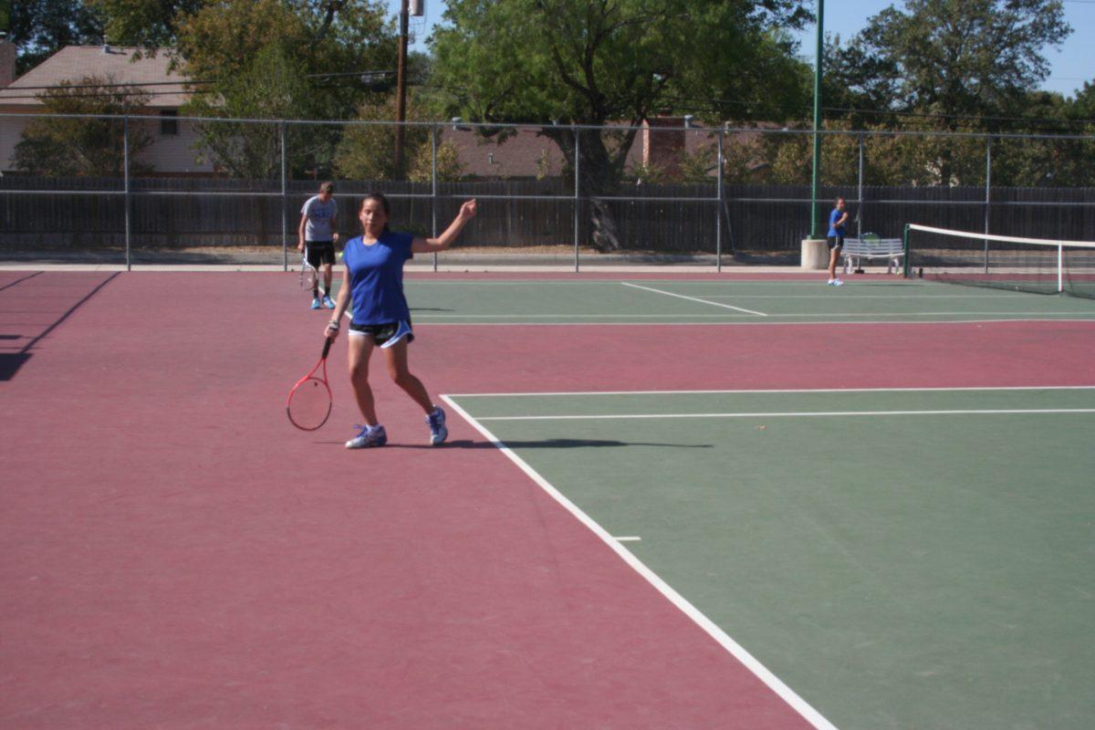 A tennis player gets ready to serve. Photo by Luke Thacker