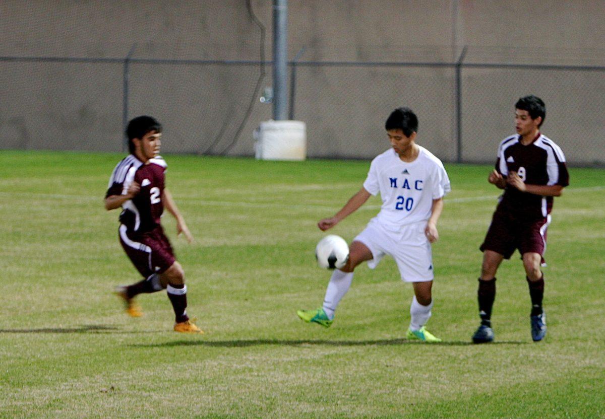 Zengwei Tong dribbles the ball away from two rams