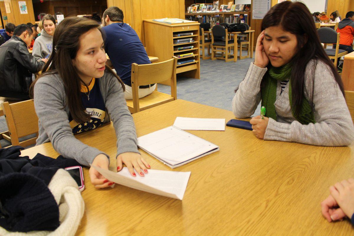 Von Pau,11, sits with her tutor Sofy Corona,12, as they go over an essay written by Von.