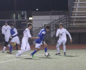 Parker Miller dribbles between two defenders. Photo by Jacob Dukes