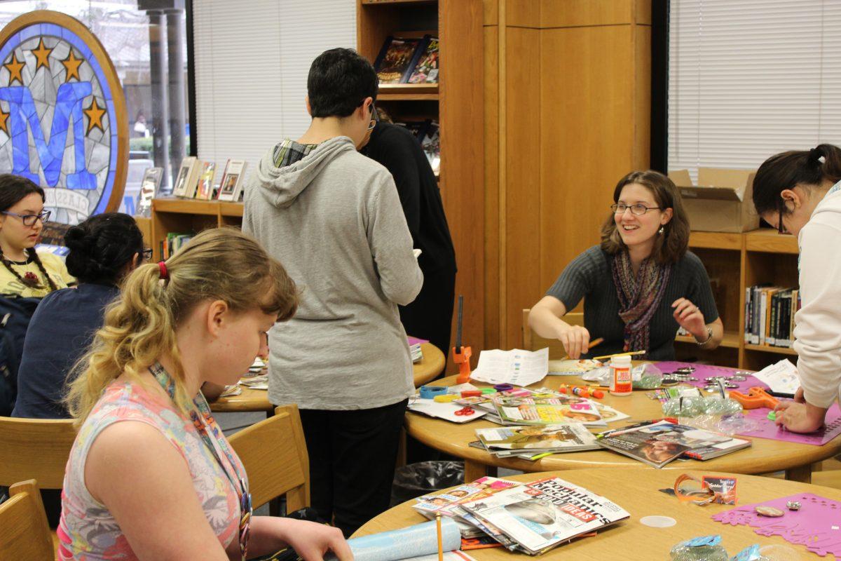 Various students and Librarian Mrs. Janelle Schnacker, kid around while gathering materials for buttons. Photo by Will Hightower.