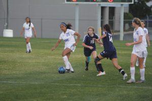 Junior Hailey Terrell receives a pass from a teammate and attempts to evade two defenders. Photo by Jacob Dukes