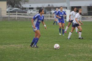 Junior Ana Campa searches for a teammate in the pouring rain. Photo by Jacob Dukes