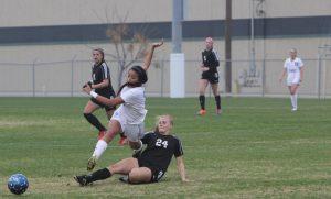 Junior Ana Campa falls after being slide tackled by a Churchill defender. Photo by Jacob Dukes