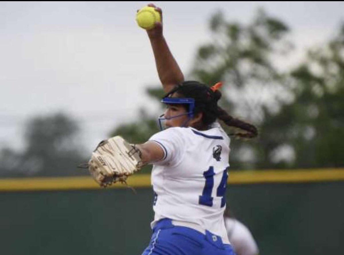 Senior Beth Montes pitching a softball.