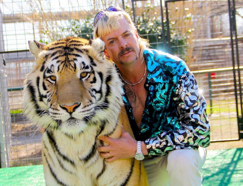 Joe Exotic posing with one of his tigers.