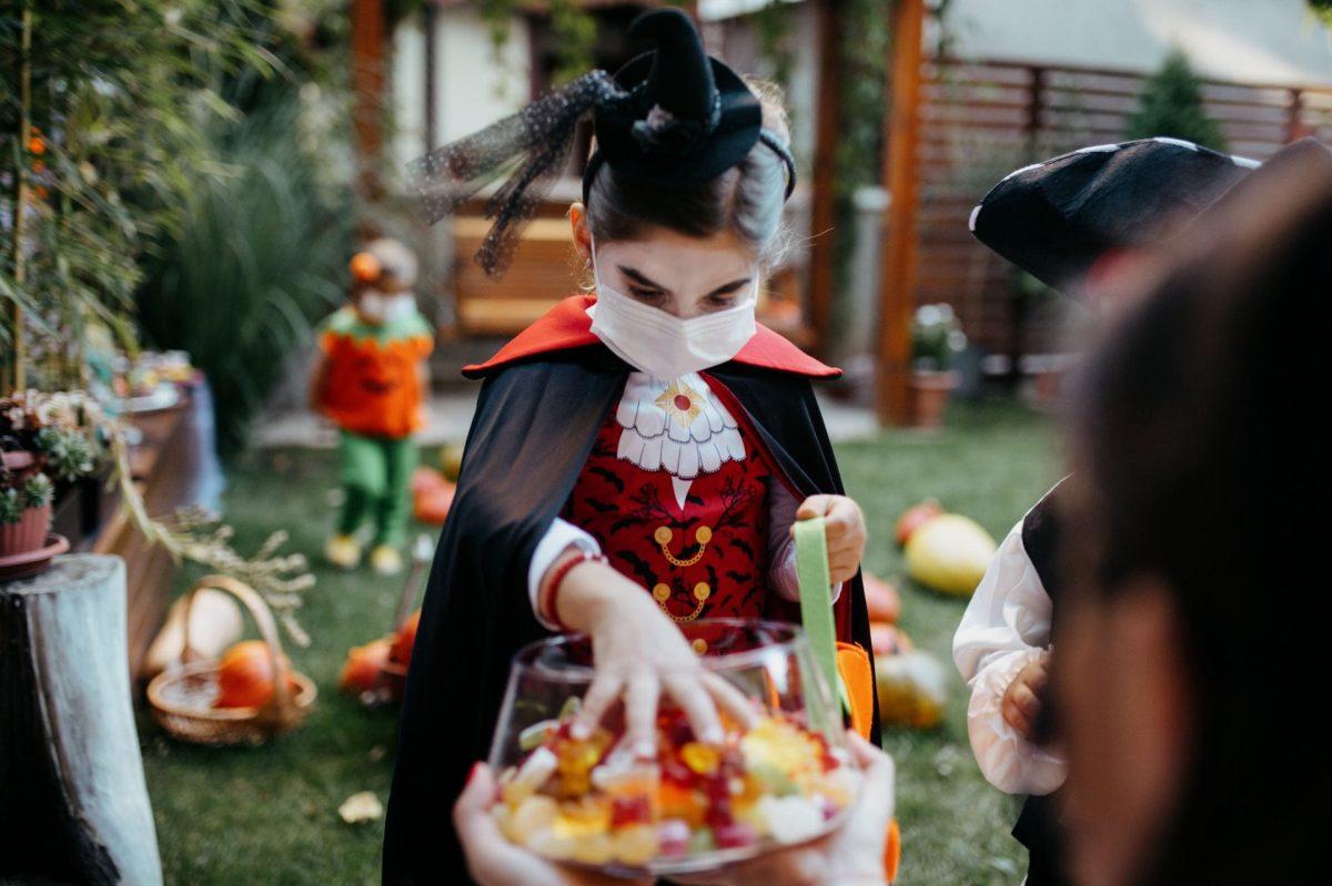 Group of kids trick or treating during Covid-19 pandemic wearing face masks